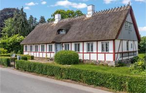 a white and red house with a roof at 3 Bedroom Awesome Home In Bog By in Bogø By