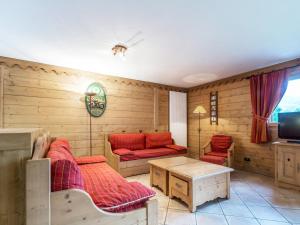 サン・マルタン・ド・ベルヴィルにあるAppartement Saint-Martin-de-Belleville, 4 pièces, 8 personnes - FR-1-461-15の木製の壁と赤い家具が備わるリビングルーム