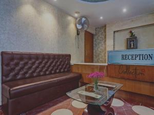 a waiting room with a leather couch and a table at Collection O THE CROWN HOTEL in Hyderabad