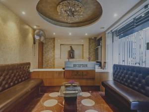 a waiting room with two leather chairs and a reception desk at Collection O THE CROWN HOTEL in Hyderabad