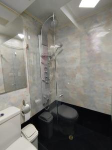 a bathroom with a toilet and a glass shower at Apartamentos Florida Nueva estadio in Medellín