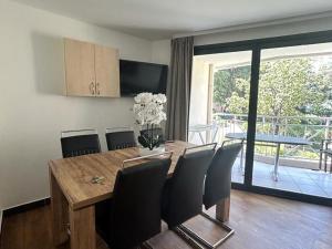 a dining room with a wooden table and chairs and a balcony at Appartement Cannes la Bocca, 3 pièces, 6 personnes - FR-1-609-76 in Cannes