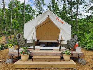 a tent with two chairs and a table in it at Tentrr Signature Site - Mountain View in Buckfield Maine in Paris