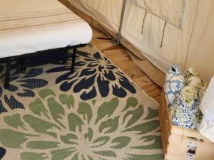 a room with a rug on the floor next to a bed at Tentrr Signature Site - Mountain View in Buckfield Maine in Paris