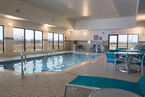 uma piscina com cadeiras e uma mesa num edifício em TownePlace Suites by Marriott Lincoln North em Lincoln