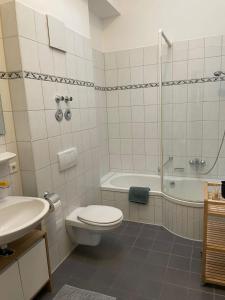 uma casa de banho com um WC, uma banheira e um lavatório. em Ferienwohnung Hofer em Altötting