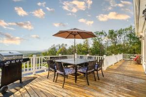 a table and chairs on a deck with an umbrella at Zen Mountainside Retreat - Spa & Amazing Views! in Hagerstown