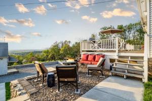 a patio with chairs and a couch and an umbrella at Zen Mountainside Retreat - Spa & Amazing Views! in Hagerstown