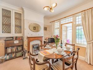 a dining room with a table and a fireplace at 15 Elms Road in Bare