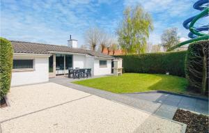 una casa con giardino attrezzato con tavolo e sedie di 3 Bedroom Awesome Home In Oostduinkerke a Oostduinkerke