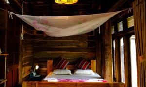 a bedroom with two beds in a wooden house at Plei Homestay & Café in Pleiku