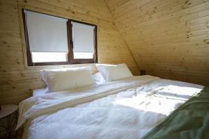 Łóżko w drewnianym pokoju z oknem w obiekcie MILLAR's w mieście Sovata