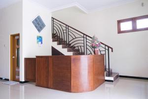 a room with a staircase and a wooden podium with a plant at Homestay Griya Kinasih Syariah Pati Mitra RedDoorz in Pati
