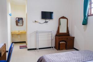 a room with a bed and a mirror and a bed sidx sidx sidx at Homestay Griya Kinasih Syariah Pati Mitra RedDoorz in Pati