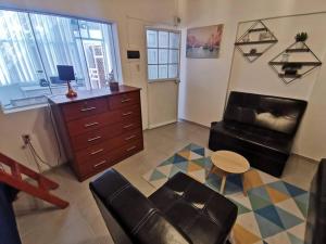 a living room with a chair and a dresser at Cómodo y bonito departamento in Santa Rosa