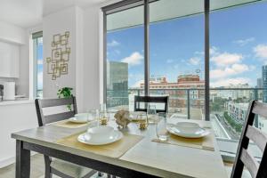 a dining room table with a view of a city at Modern Luxury 2 Bed with Panoramic City Views in Downtown LA in Los Angeles