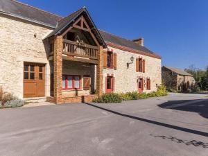 ein großes Backsteingebäude mit Balkon in der Unterkunft Rustique, Confort et Détente Près de Nantes: Chambre Équipée avec Petit-Déjeuner Inclus - FR-1-306-1254 in Bouvron