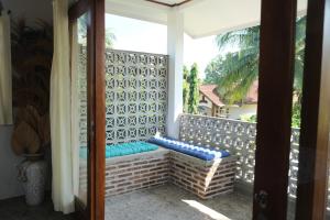 a porch with a bench on a balcony at Hideaway Batukaras in Batukaras