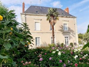 una palmera frente a una casa con flores en Guestroom Renazé, 1 pièce, 2 personnes - FR-1-600-230, en Congrier