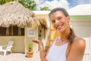 a woman standing in front of a house at Garden house by Petraki in Las Galeras