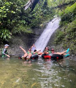a group of people in the water in front of a waterfall at Casa hospedaje mayesty in San Cipriano