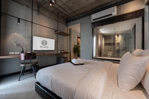 sypialnia z dużym białym łóżkiem i biurkiem w obiekcie EX2 Hotel w mieście Ban Bang Khen (1)