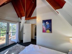 a bedroom with white walls and a ceiling with wooden beams at Winding Creek Cottage in Bald Knob