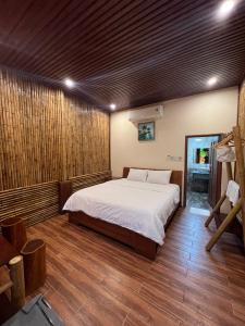 1 dormitorio con 1 cama y suelo de madera en Homestay Da Nang Full House, en Da Nang