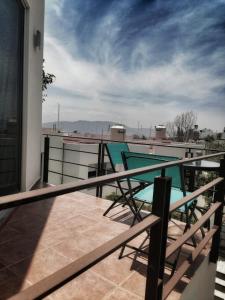 een balkon met twee stoelen bovenop een huis bij Casa del Pibe Piola in Oaxaca City