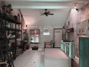 ein Wohnzimmer mit einem Deckenventilator in einem Zimmer in der Unterkunft Artist Heritage Penang UNESCO Home (Lebuh Armenian) in George Town + 11 Fotos