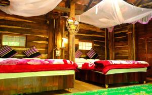 a bedroom with two beds in a log cabin at Plei Homestay & Café in Pleiku