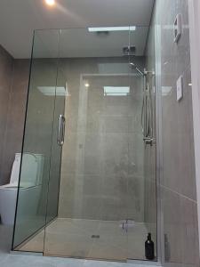 a glass shower in a bathroom with a toilet at Taimana Boutique Motel in Diamond Harbour