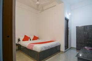 a bedroom with a bed with red pillows on it at Jp Homes in Kamakhya