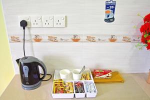 a kitchen counter with a coffee pot and some food at Tourist Inn in Male City