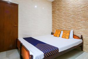 una camera da letto con un letto con cuscini arancioni e blu di OYO Hotel Prince Residency a Vellore