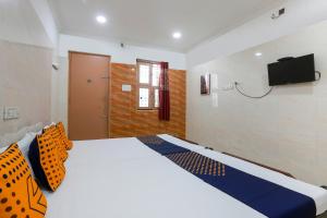 a bedroom with a bed and a television on the wall at OYO Hotel Prince Residency in Vellore