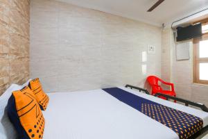 a bedroom with a bed and a red chair at OYO Hotel Prince Residency in Vellore