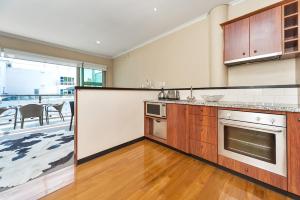 a kitchen with wooden cabinets and a counter top at QV Down at the Viaduct (861) in Auckland