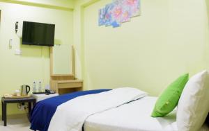 een slaapkamer met een bed en een flatscreen-tv bij Tourist Inn in Male City