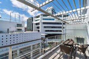 a balcony with a table and chairs on a building at QV Down at the Viaduct (861) in Auckland