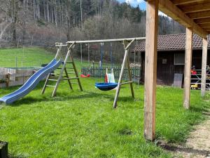 - une aire de jeux avec 2 balançoires dans l'herbe dans l'établissement Ferienwohnungen Dopplerhof, à Piding
