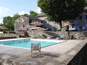 een zwembad met een stoel voor een huis bij Séjour champêtre : magnifique ferme réhabilitée avec piscine, terrasses et confort moderne à St Étienne Lardeyrol - FR-1-582-389 in Saint-Étienne-Lardeyrol +23 foto's
