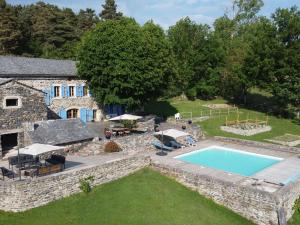una vista aerea di una casa in pietra con piscina di Guestroom Saint-Étienne-Lardeyrol, 1 pièce, 2 personnes - FR-1-582-396 a Saint-Étienne-Lardeyrol