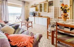 sala de estar con sofá, mesa y cocina en Amazing Apartment In Santa Pola With Kitchen, en Santa Pola