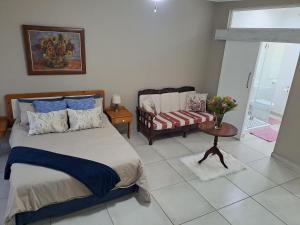 a bedroom with a bed and a couch and a table at Berlydai Guest Accomodation in Secunda
