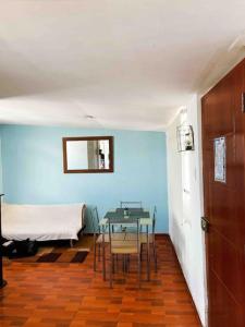 a table and chairs in a room with a blue wall at Departamento con vista panoramica in Cusco