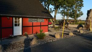 a red building with a sign in front of it at Jungshoved Kro B&B in Præstø