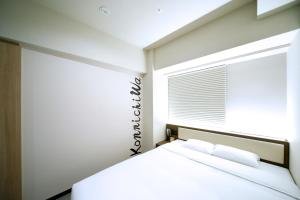 a white bedroom with a bed and a window at Travelodge Kyoto Shijo Kawaramachi in Kyoto