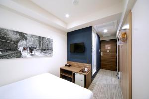 a hotel room with a bed and a tv at Travelodge Kyoto Shijo Kawaramachi in Kyoto