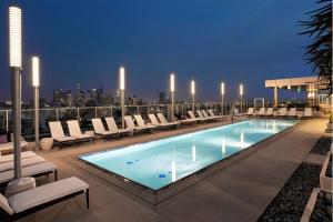 a swimming pool on the roof of a building at Modern Luxury 2 Bed with Panoramic City Views in Downtown LA in Los Angeles